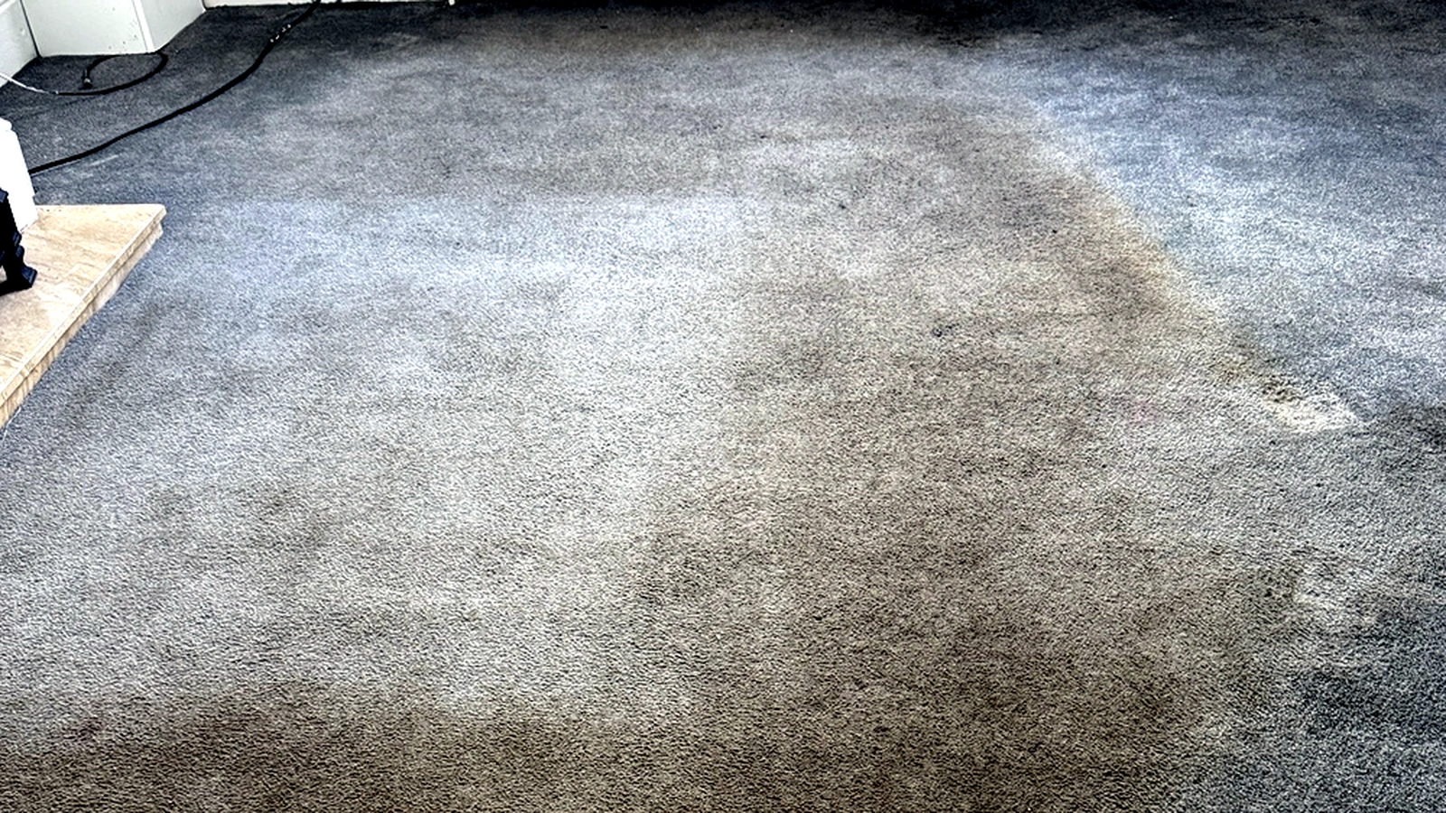 Heavily soiled grey dining room carpet with embedded dirt and traffic staining before professional cleaning