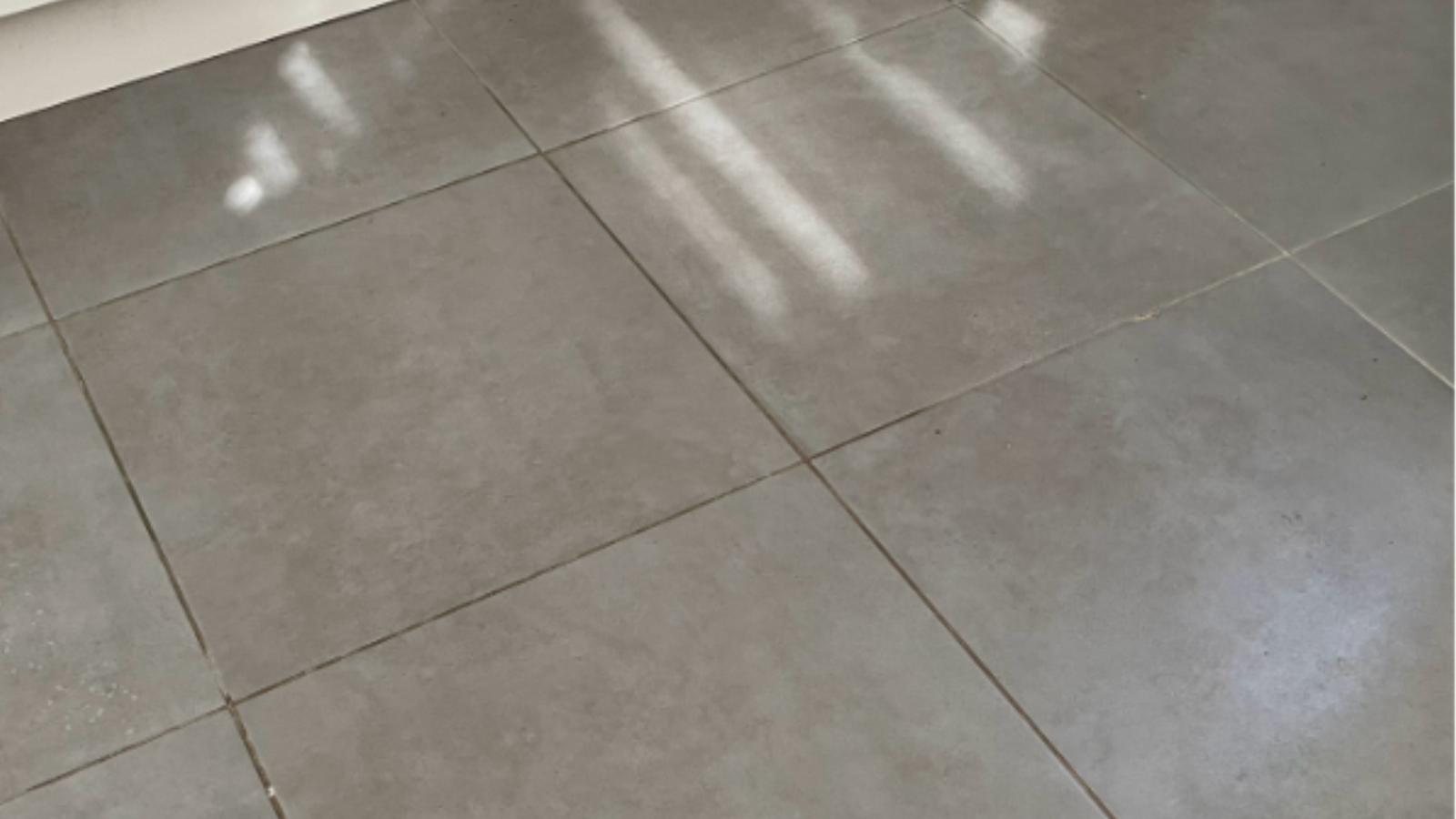 Ceramic kitchen floor tiles in Houghton-le-Spring with dark dirty grout lines before professional cleaning