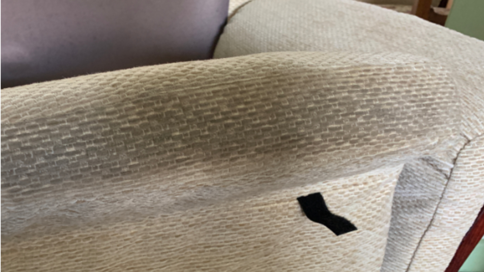 Fabric sofa arm with heavy body oil and dirt build-up before upholstery cleaning in Durham