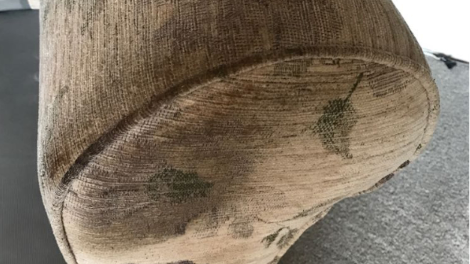 Fabric sofa arm with heavy body oil and grease build-up before upholstery cleaning