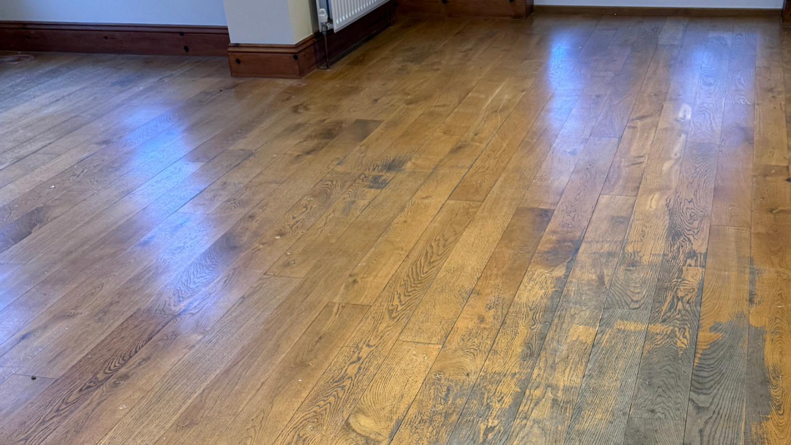 Worn solid oak plank flooring before sanding and restoration