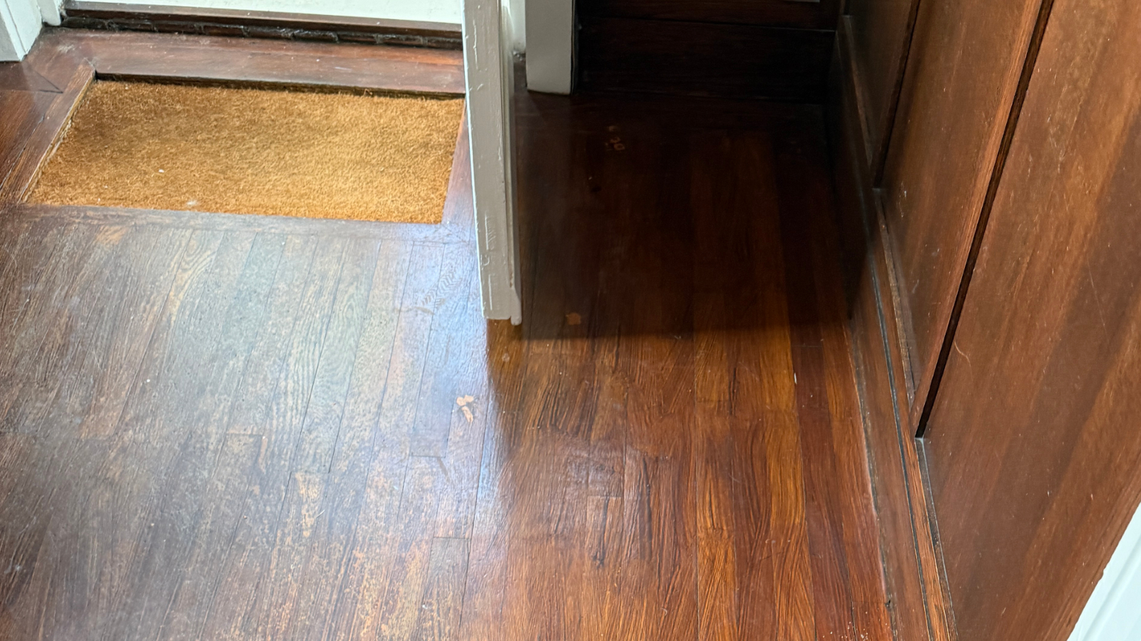 Dark varnished oak strip floor before restoration in a 1930s detached home in Jarrow